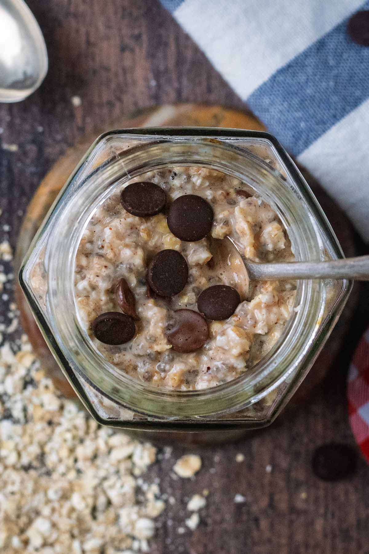 A jar of overnight oats topped with some chocolate chips.