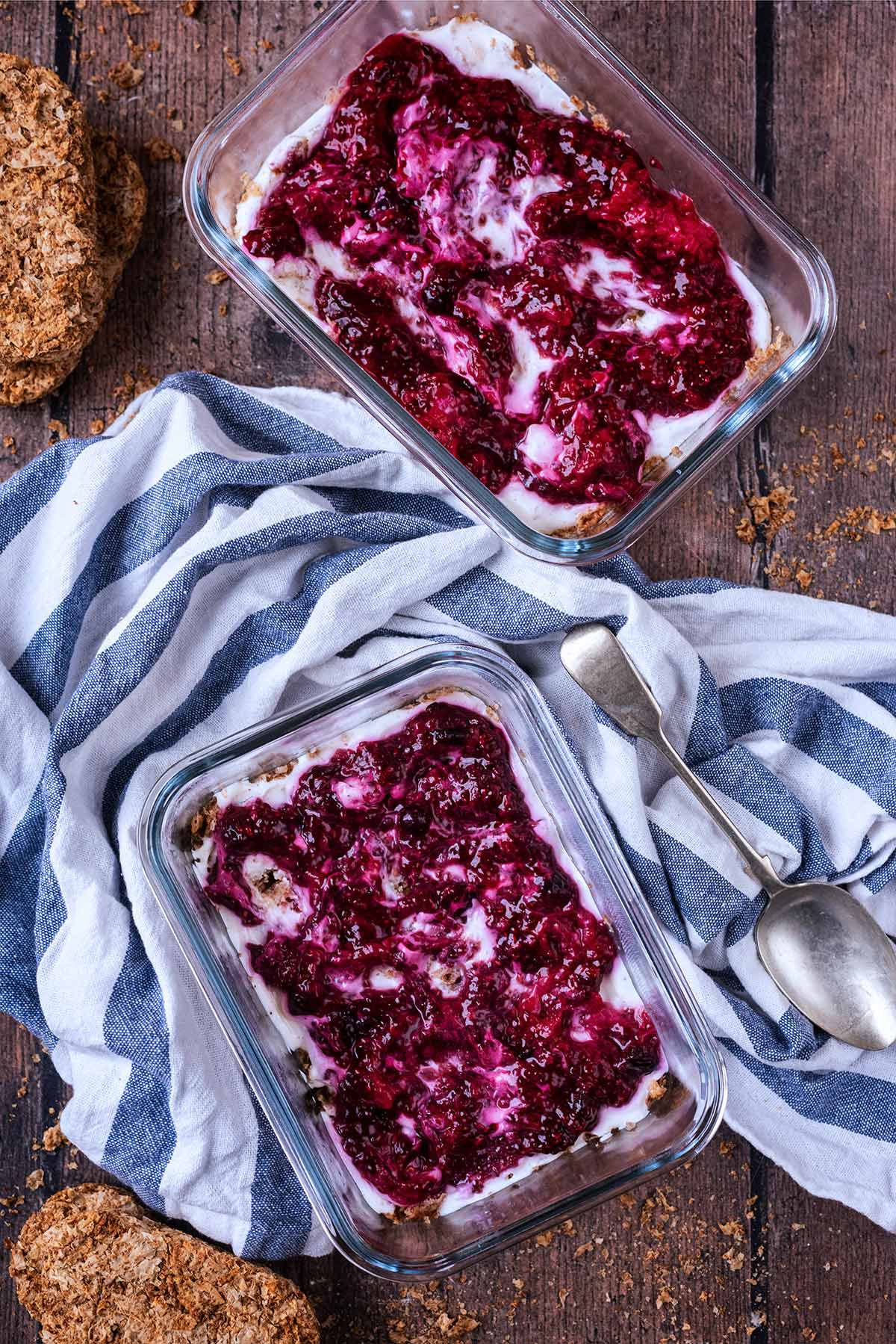 Two glass containers full of jam topped overnight Weetabix.