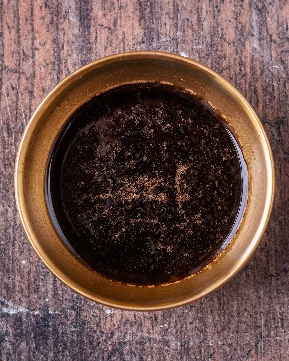 A small bowl of thin, dark brown sauce.