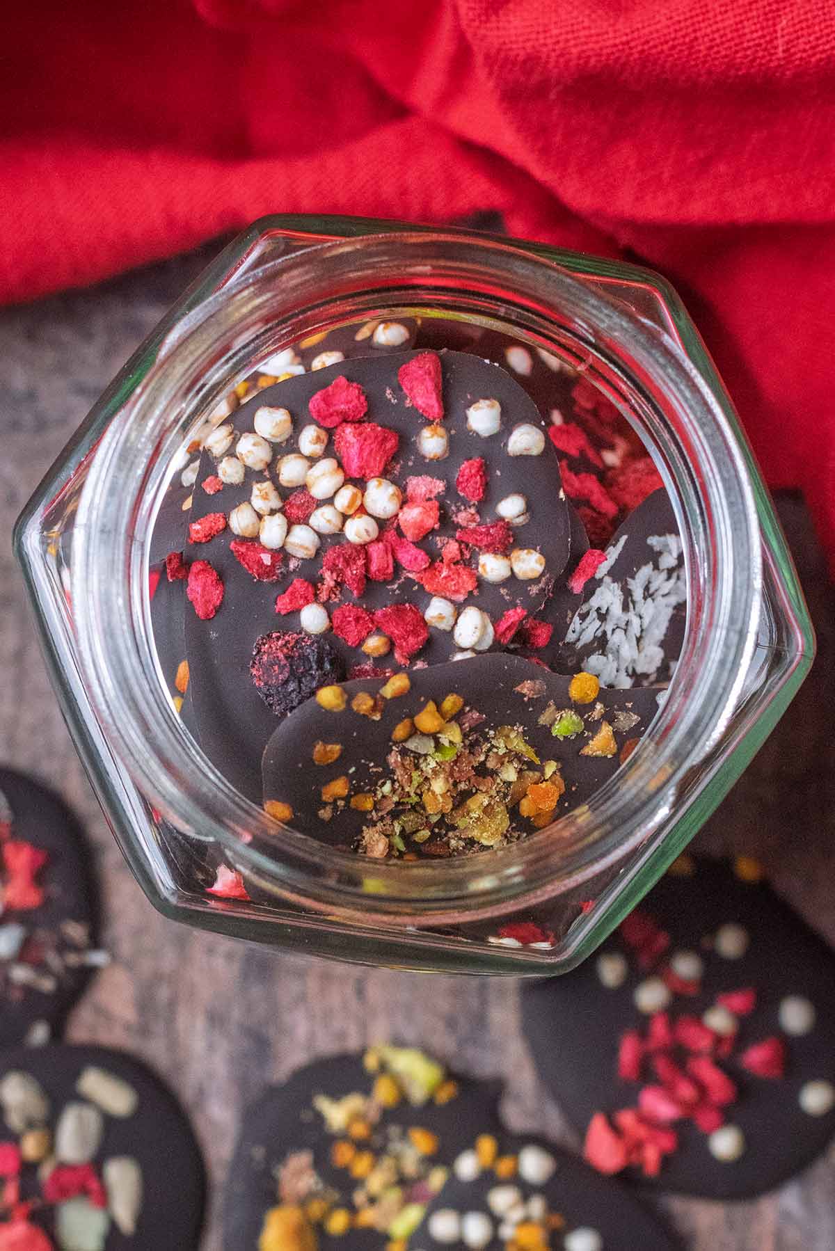 A jar of dark chocolate buttons as viewed from above.