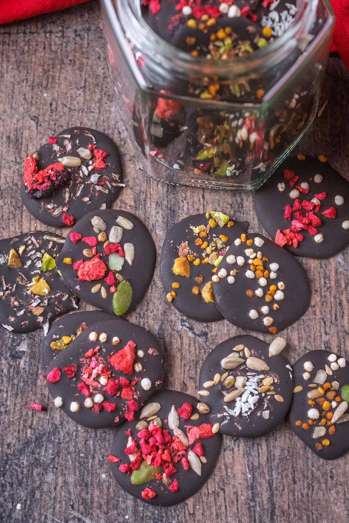 Homemade chocolate buttons scattered over a wooden surface.