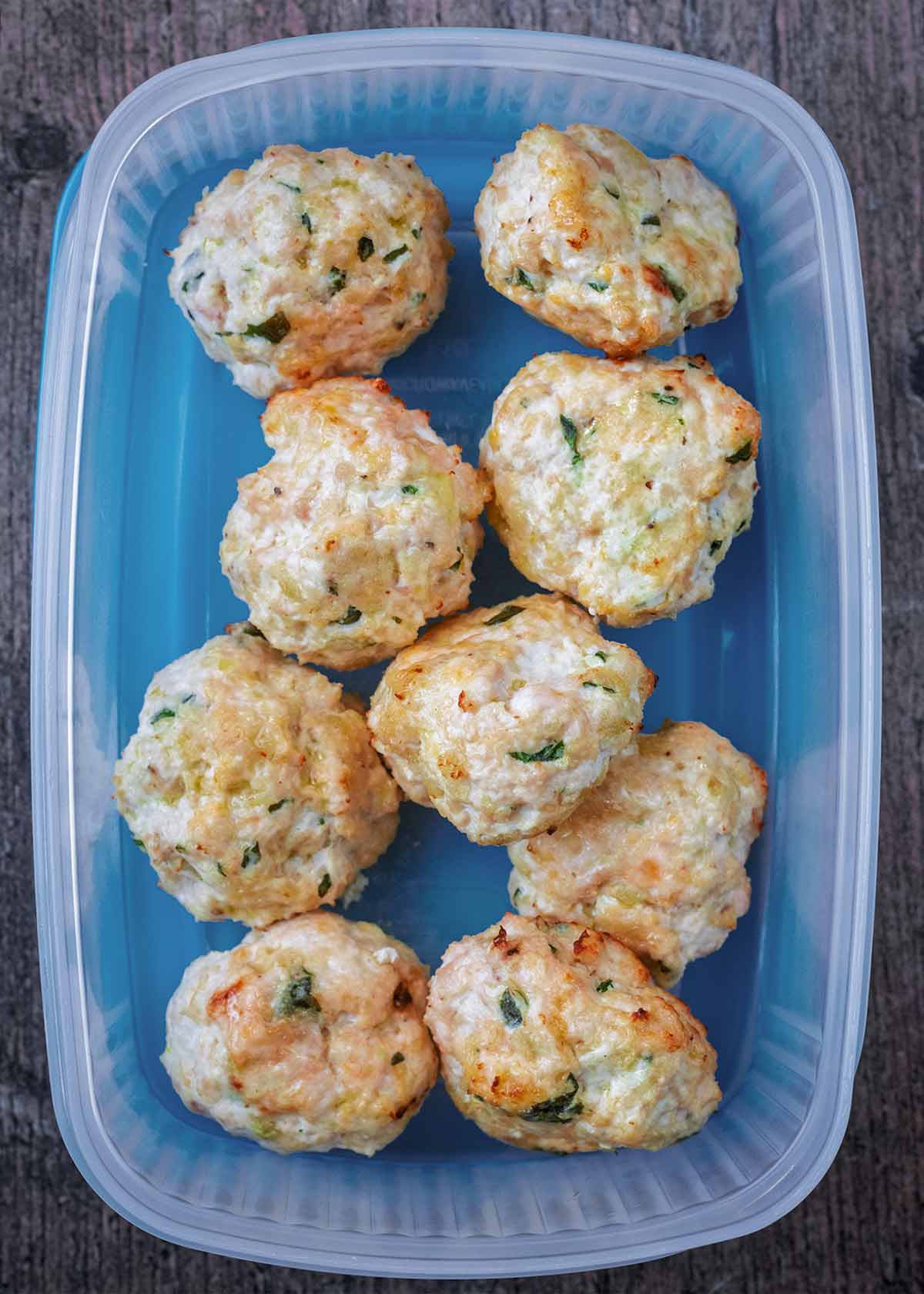 Nine chicken meatballs in a plastic container.