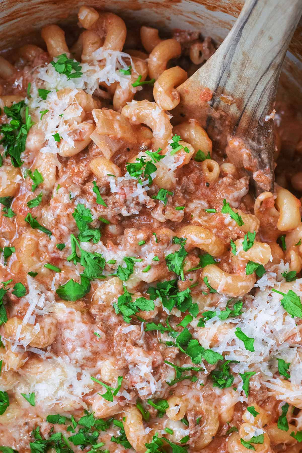 Grated parmesan cheese and chopped parsley on top of beef pasta.