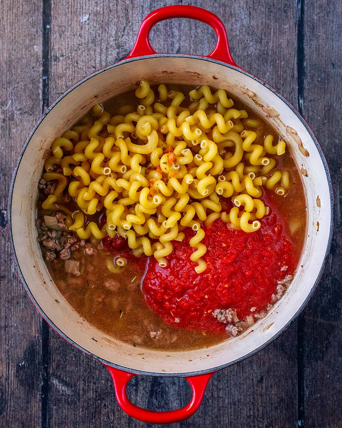 Pasta shapes, chopped tomatoes and stock added to the pan.