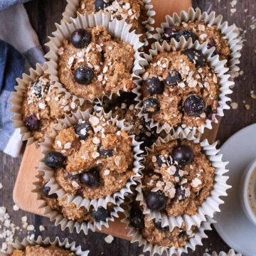 A stack of high fiber breakfast muffins on a wooden board.