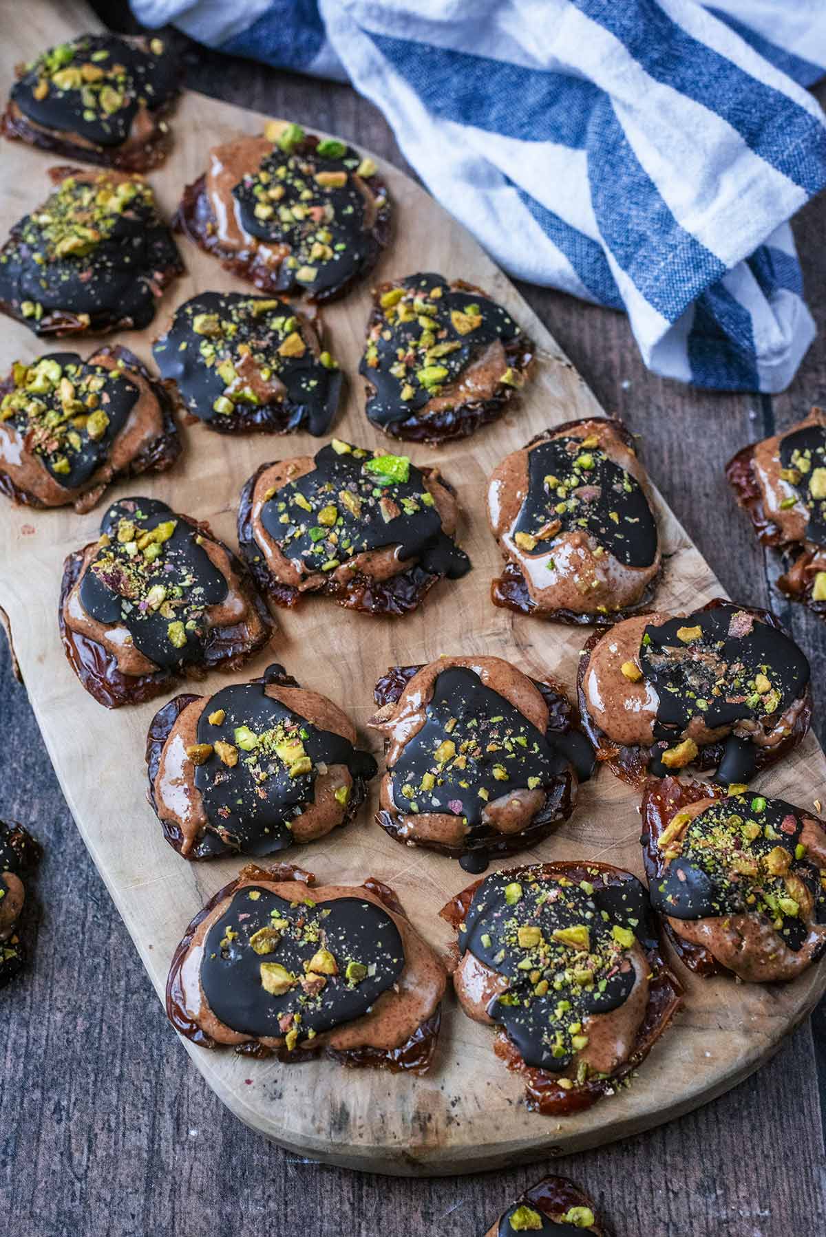 Fifteen pieces of date bark on a wooden serving board.