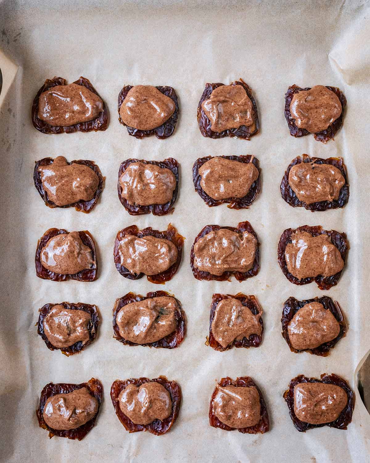 A small amount of almond butter on top of each flattened date.