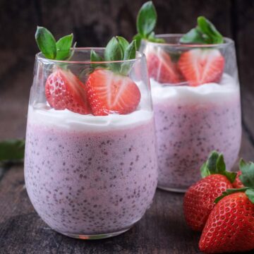 A serving glass full of strawberry chia pudding with another pudding in the background.