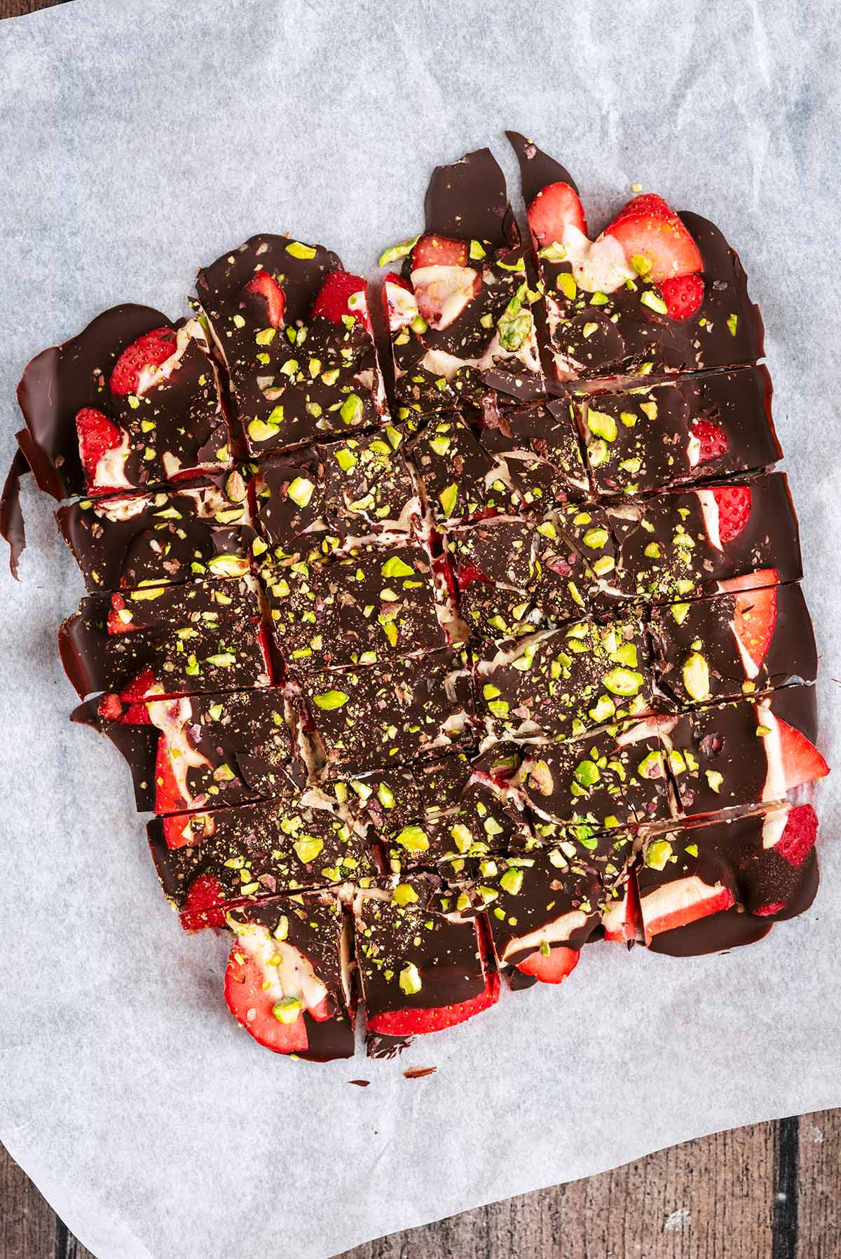 A slab of strawberry bark on a sheet of parchment paper.