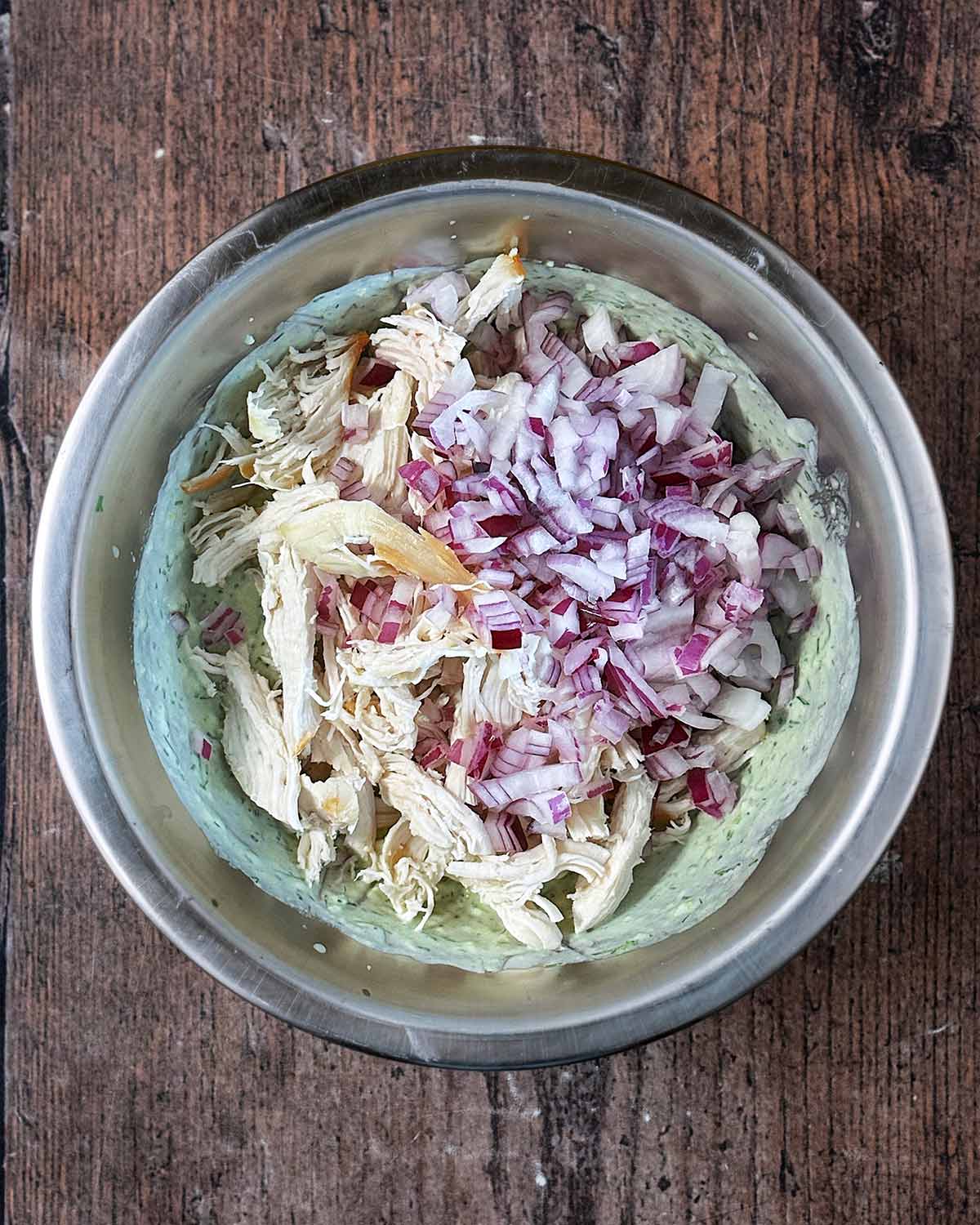 Chopped red onion and shredded cooked chicken added to the sauce.