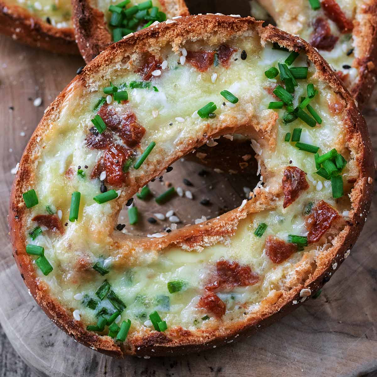 Breakfast bagel boats on a wooden board.