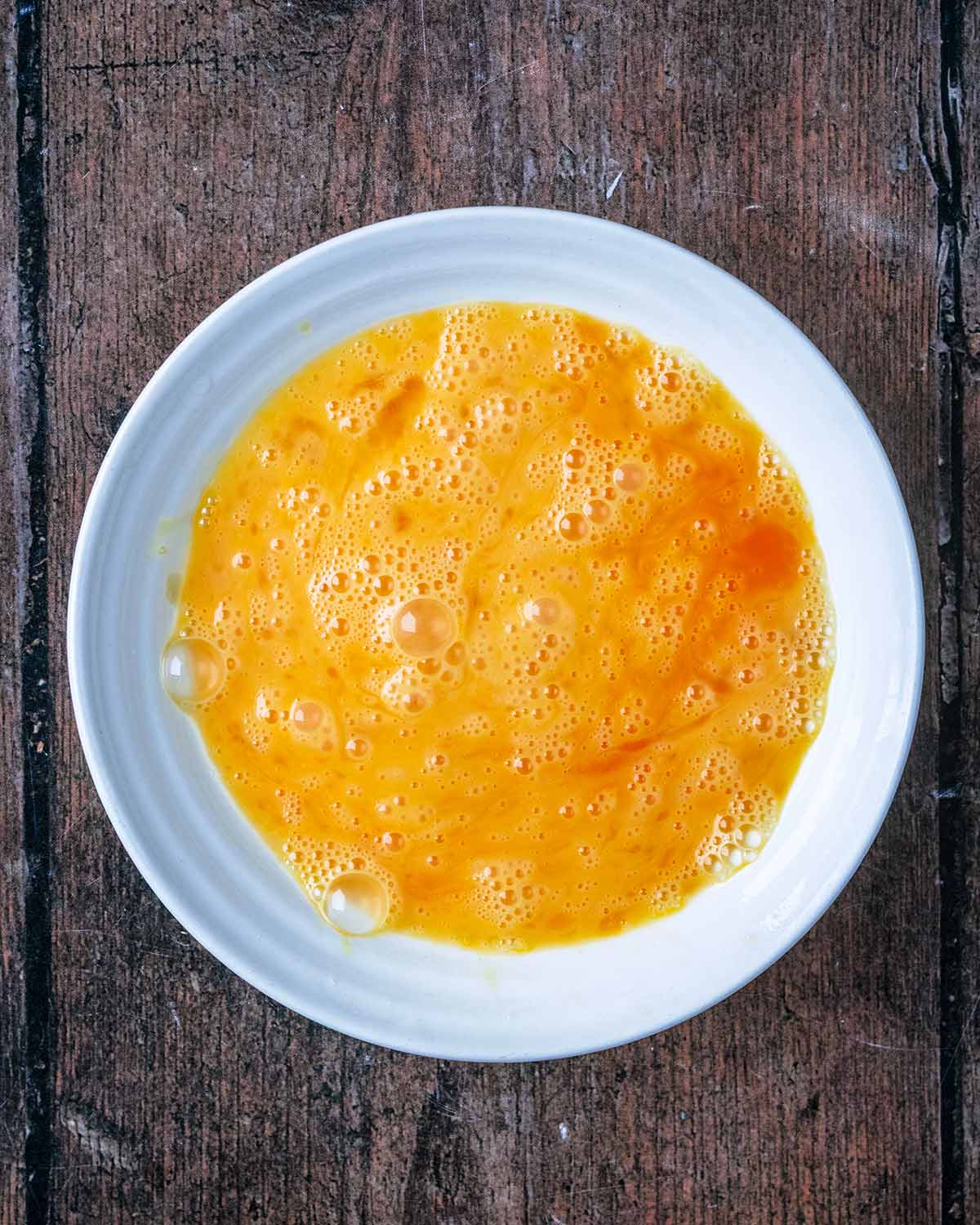 Eggs whisked in a bowl.