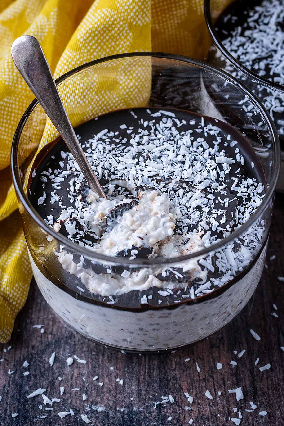 A spoon pushed through the chocolate layer on top of the overnight oats.