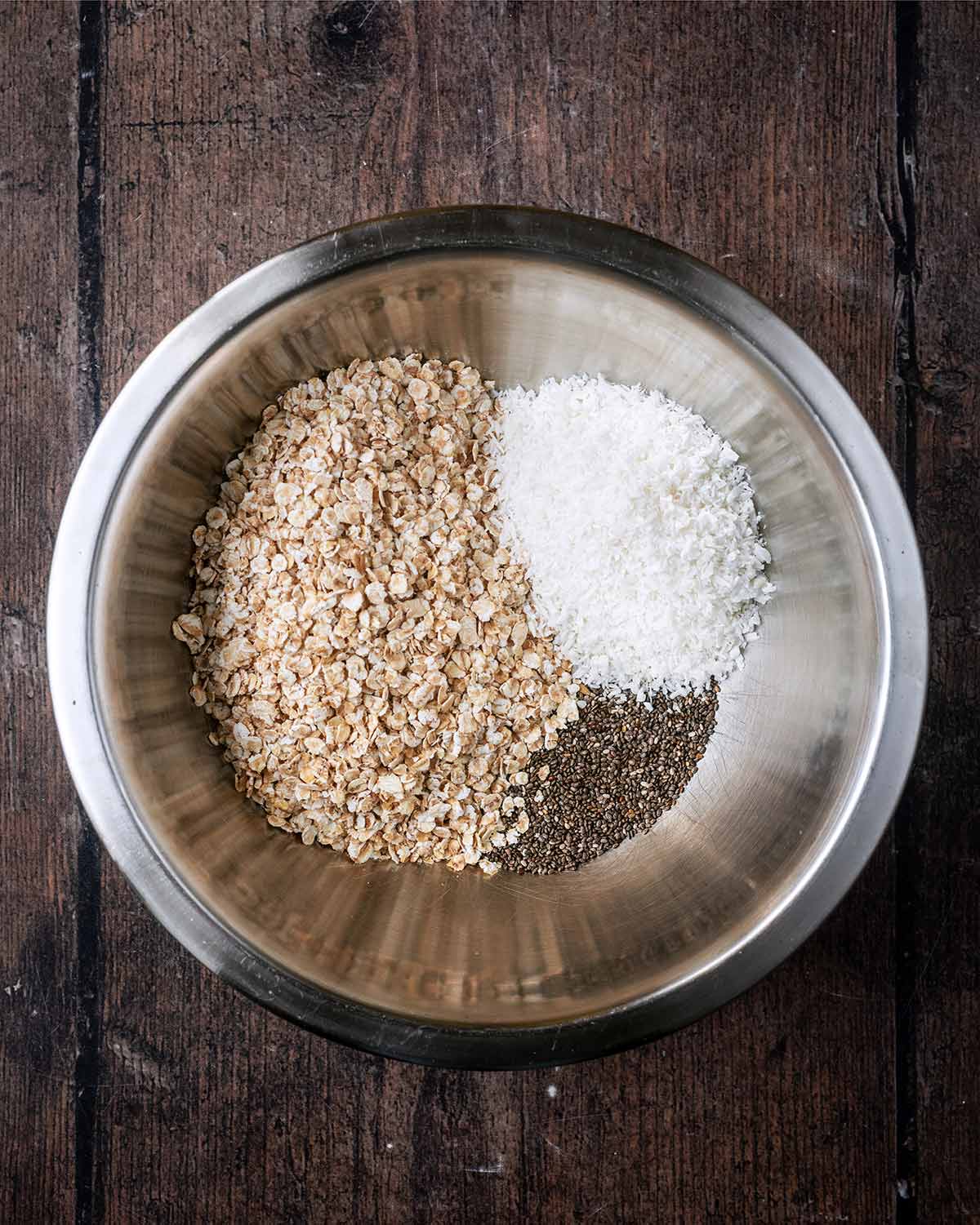 Oats, desiccated coconut and chia seeds in a mixing bowl.