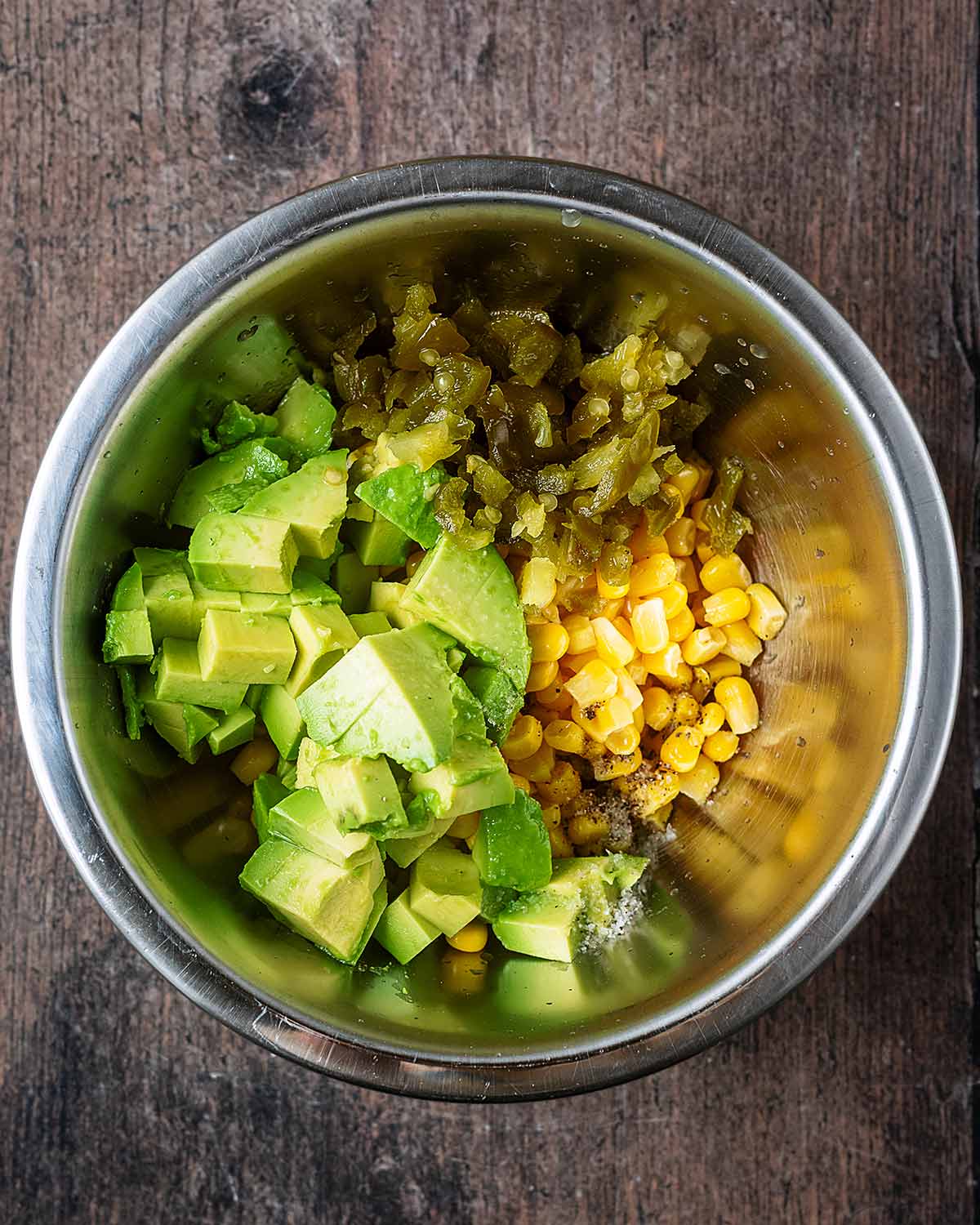 A mixing bowl containing sweetcorn, diced avocado and chopped jalape&ntilde;oes.