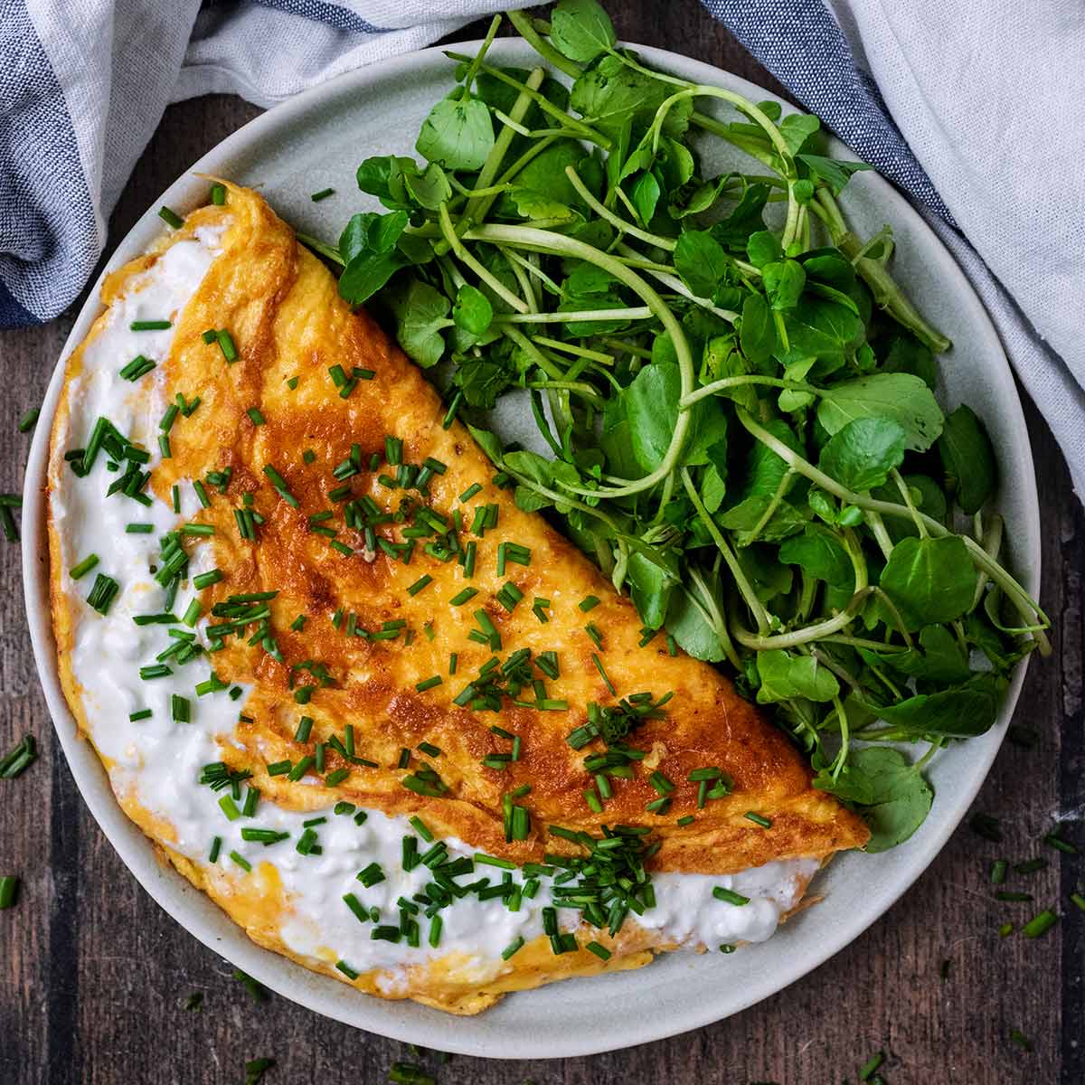 Cottage cheese omelette on a plate with green salad leaves.