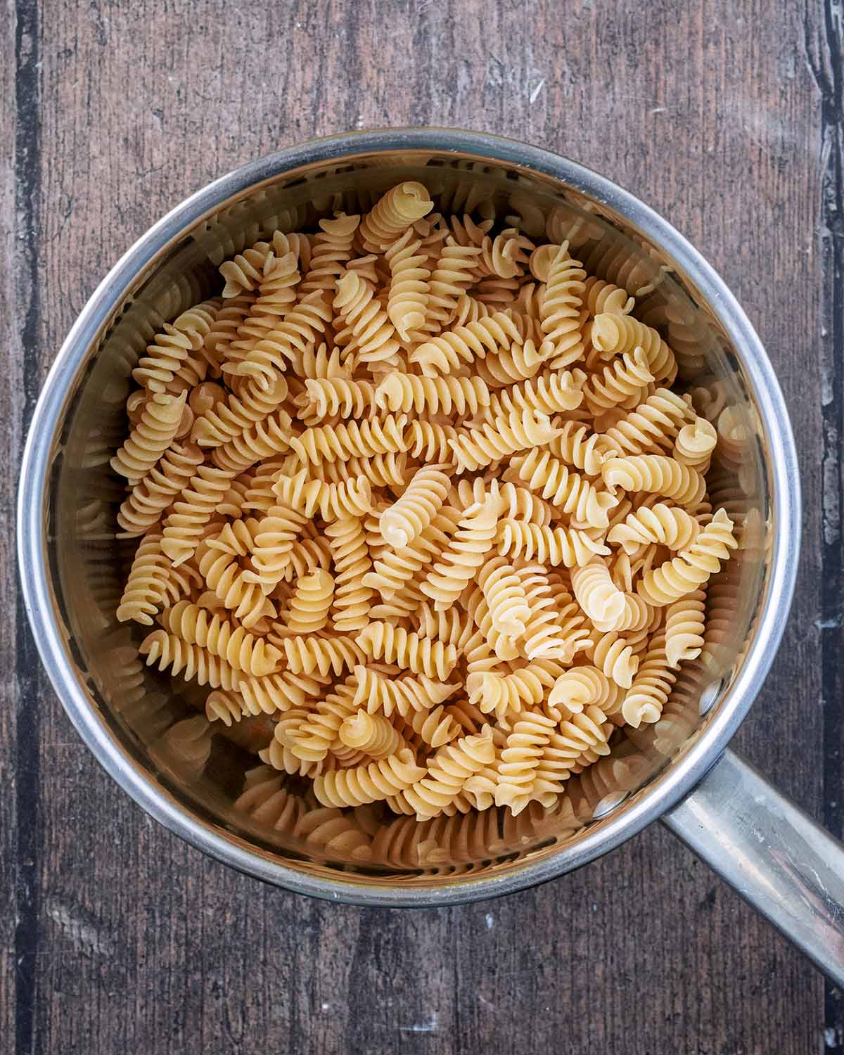 Cooked pasta shapes in a saucepan.