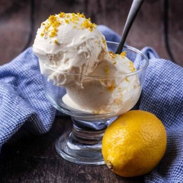 Ninja Creami Lemon Ice Cream in a serving bowl next to a whole lemon.