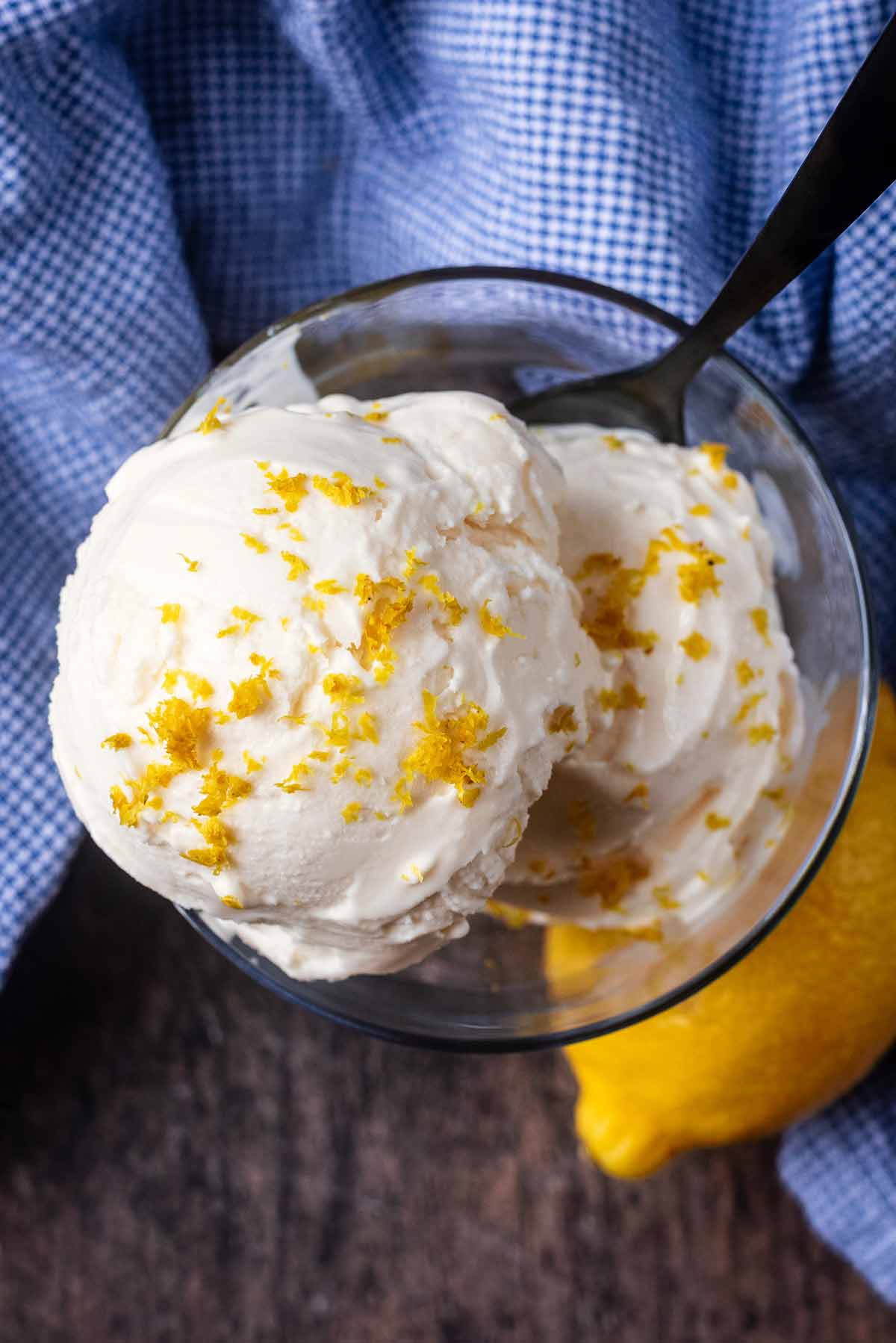 Two balls of lemon ice cream topped with grated lemon zest.