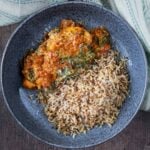 Slow cooker pesto chicken in a bowl with cooked rice.