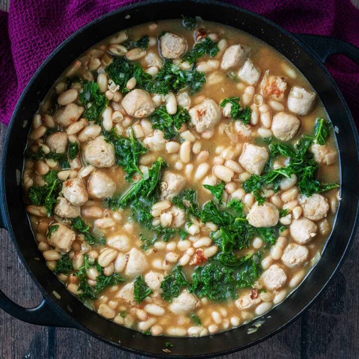 White bean and chicken sausage skillet next to a purple towel.