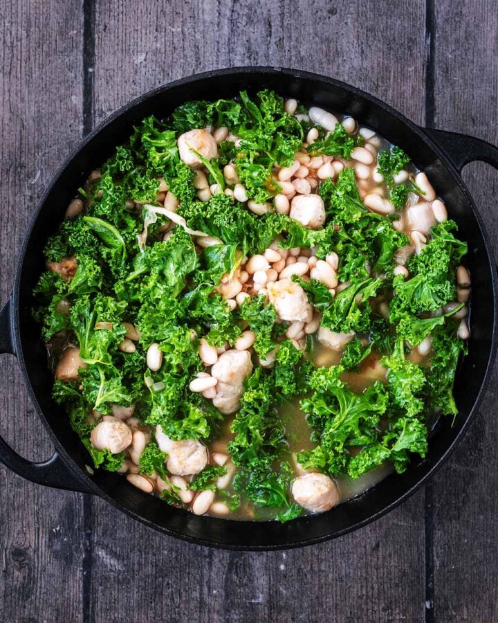Stock, beans and kale added to the pan.