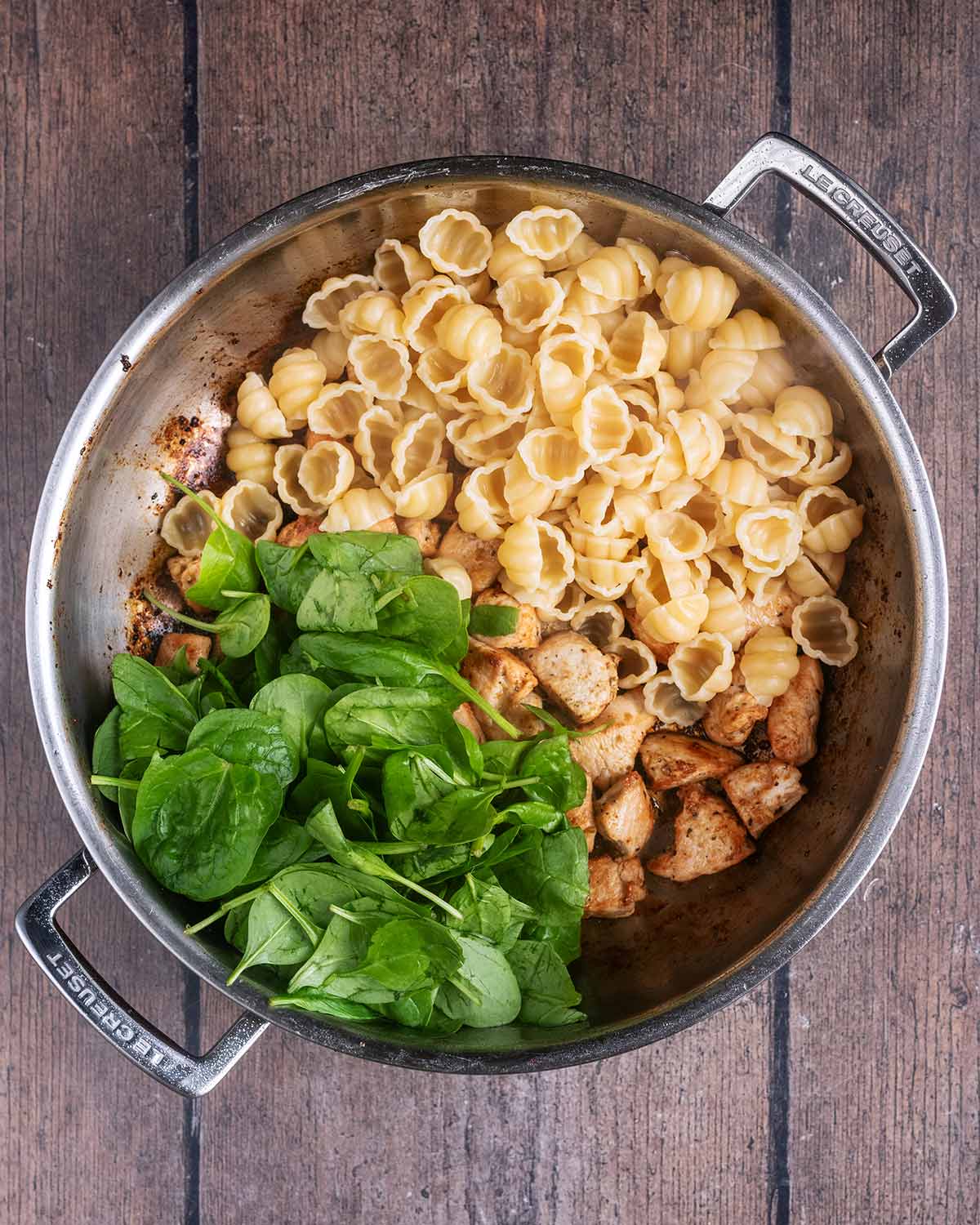 Cooked pasta, spinach and sun-dried tomatoes added to the pan of chicken.