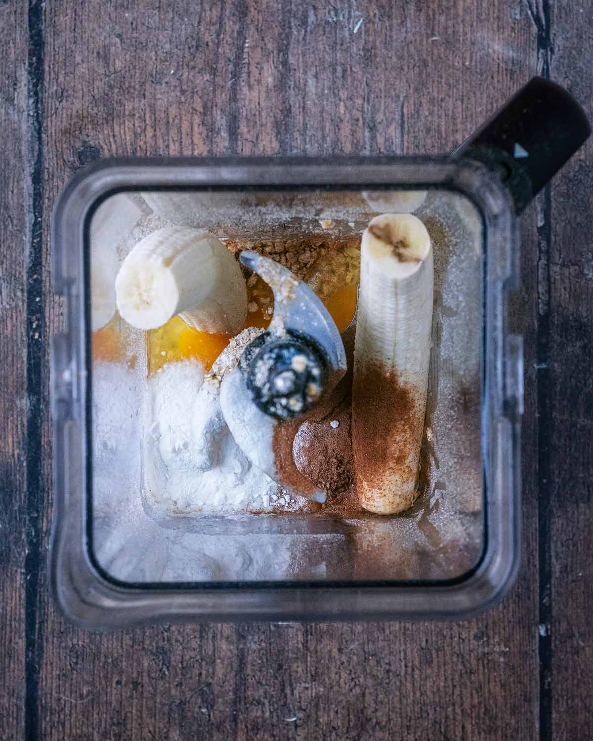 Oats, bananas, maple syrup, vanilla, eggs and milk in a blender jug.