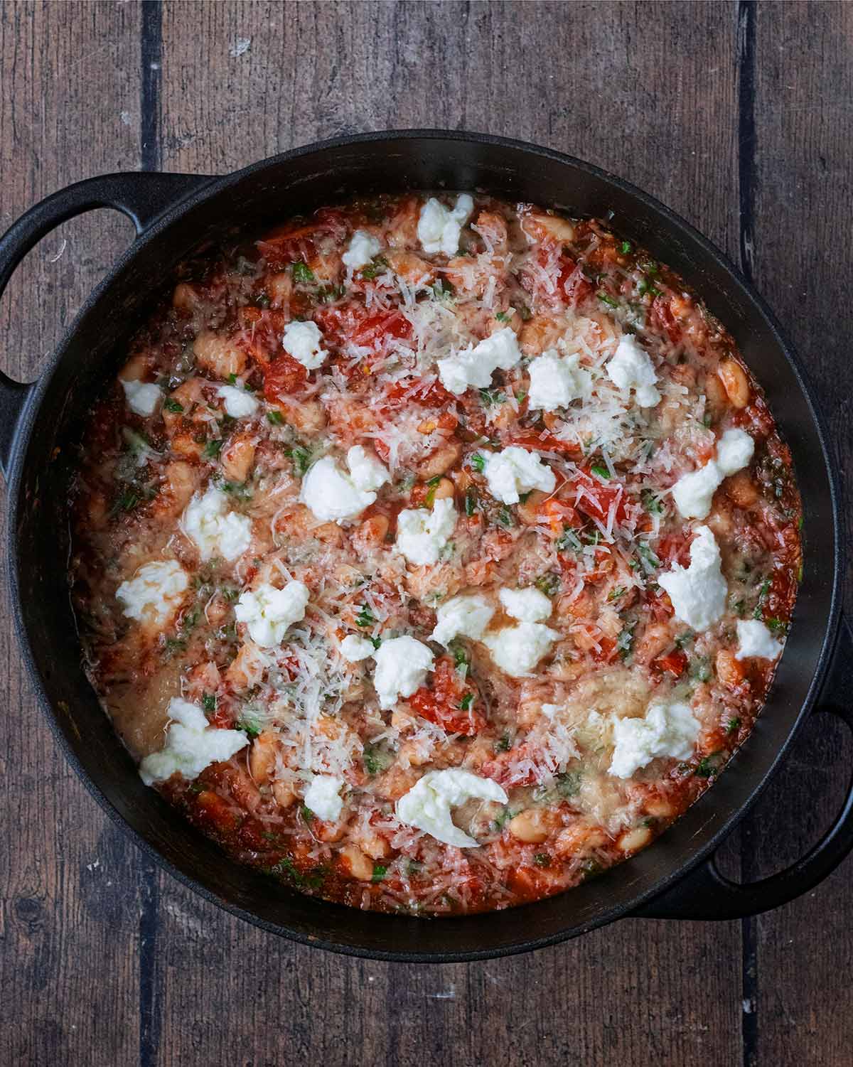 Grated Parmesan and small dots of torn Mozzarella on top of the cooked beans.