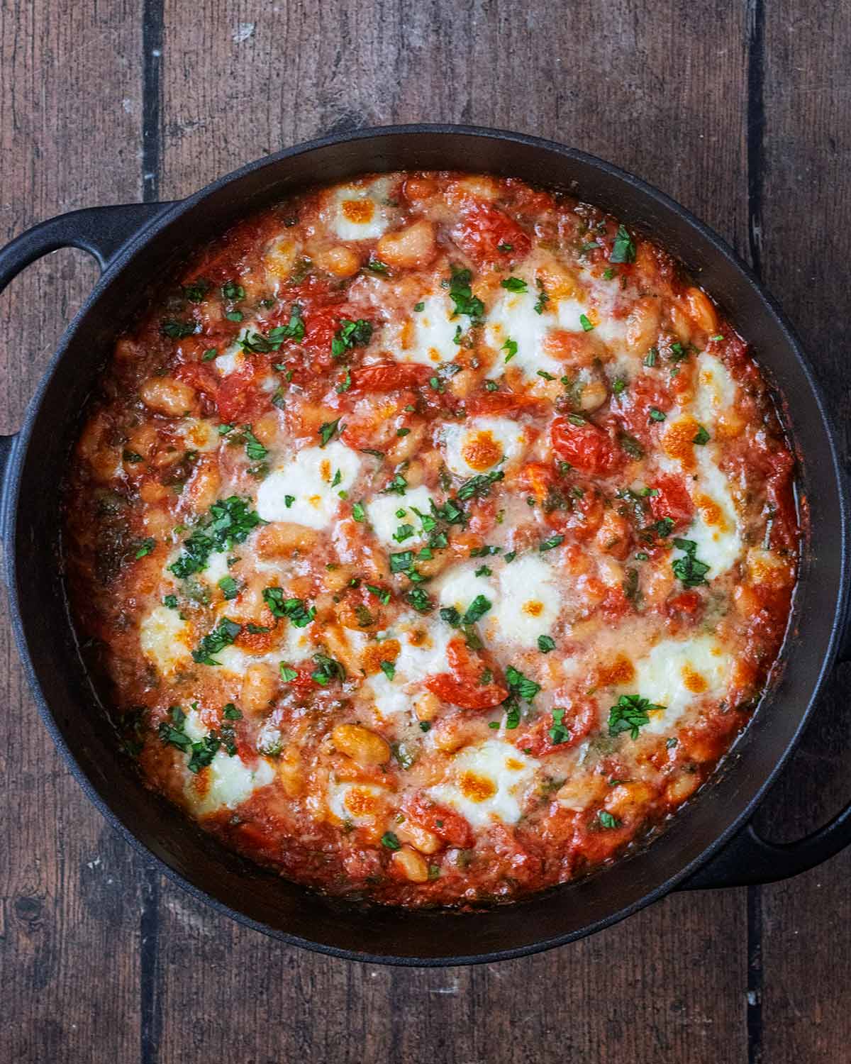 Baked tomato beans with a melted cheesy top.
