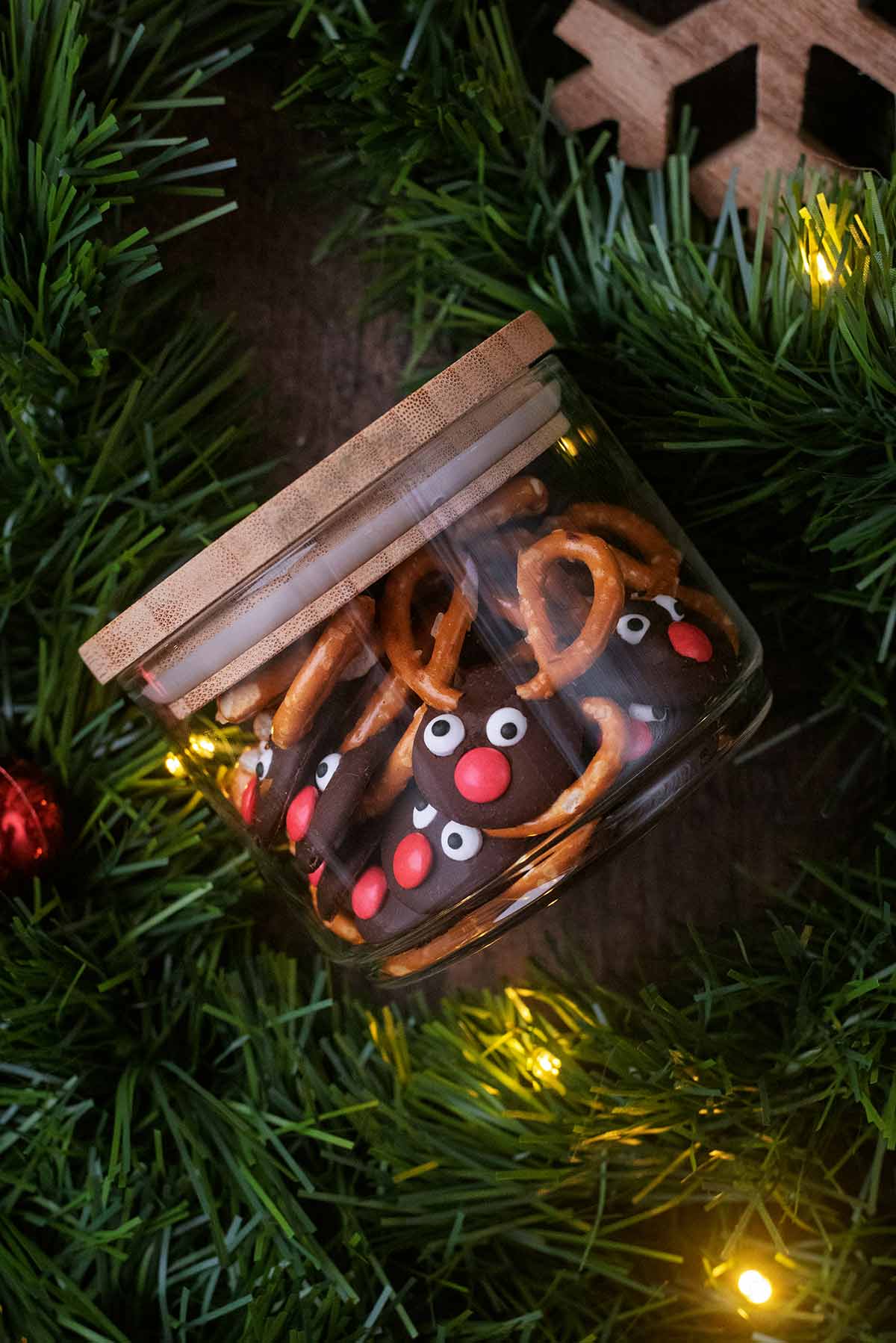 A glass jar filled with chocolate button reindeer.