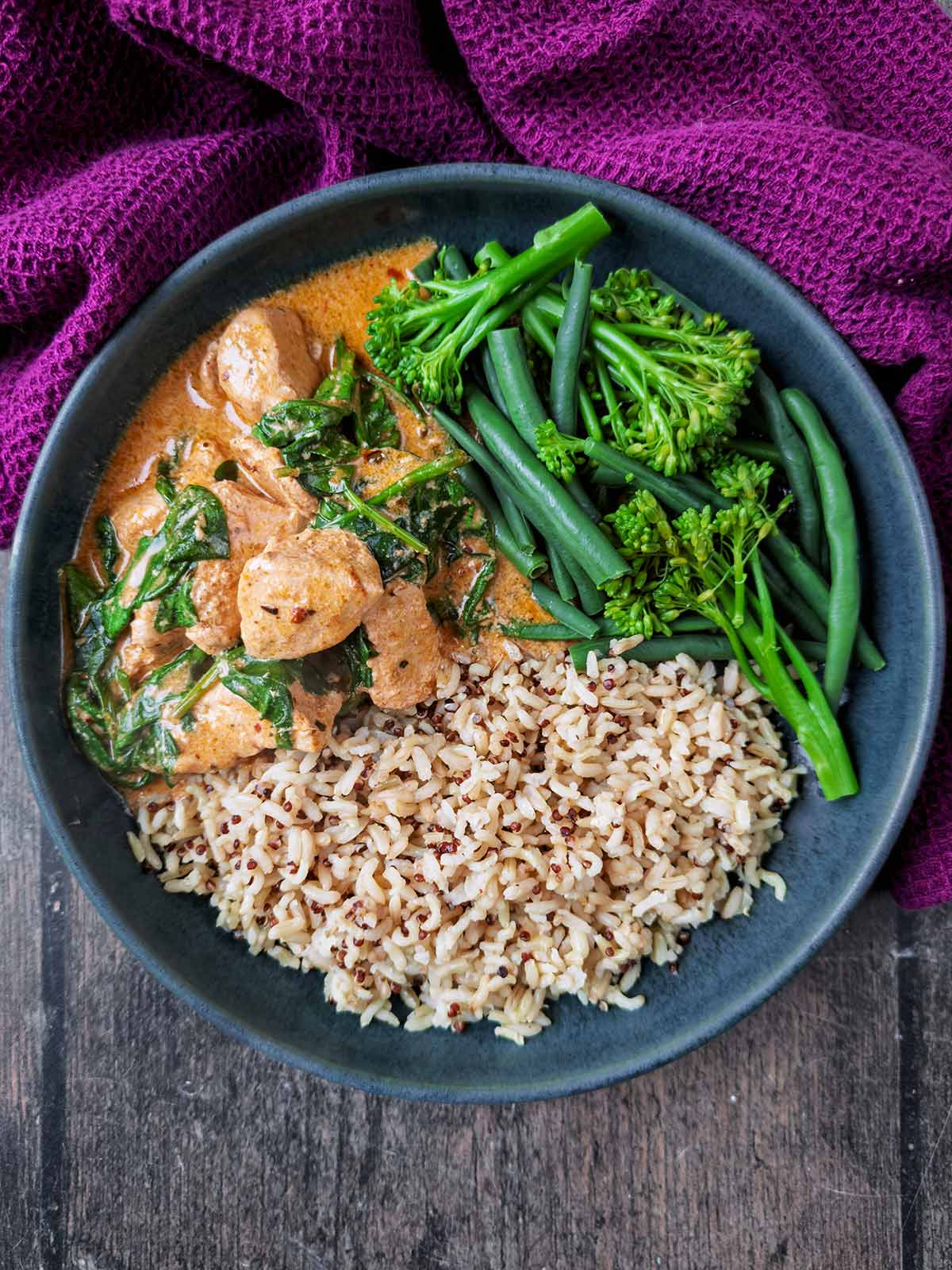 A bowl of curry, rice and broccoli.