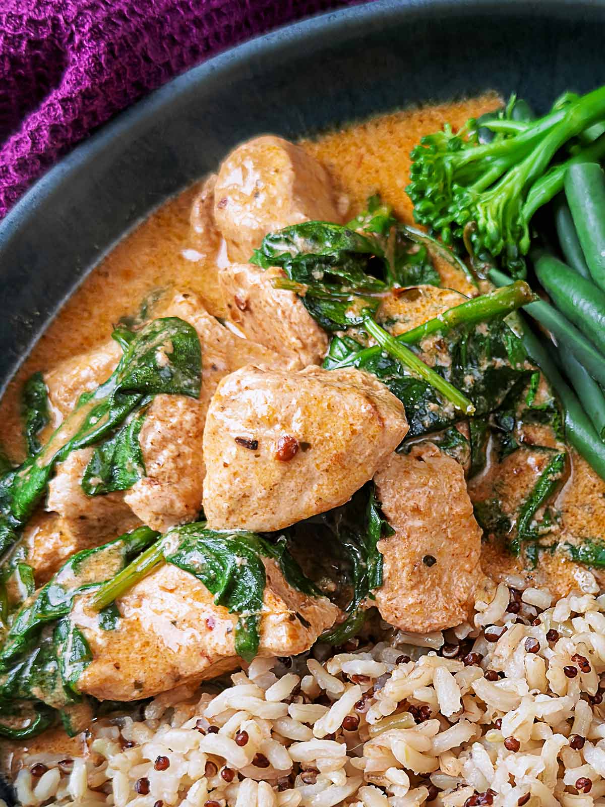 Chunks of cooked chicken in a Thai red curry sauce.