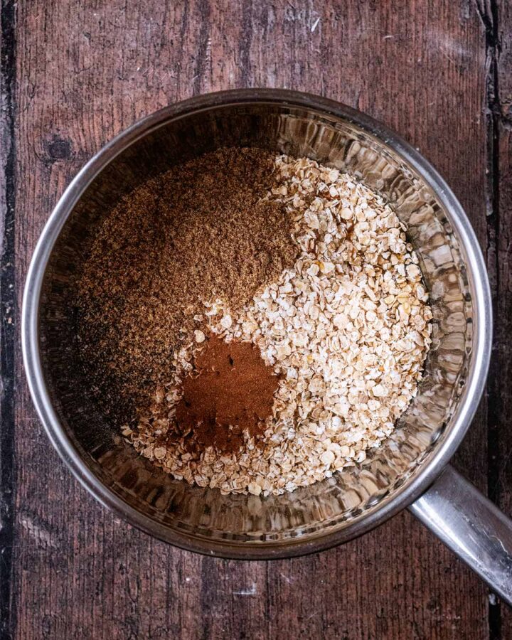 A saucepan with oats, seeds and cinnamon in it.