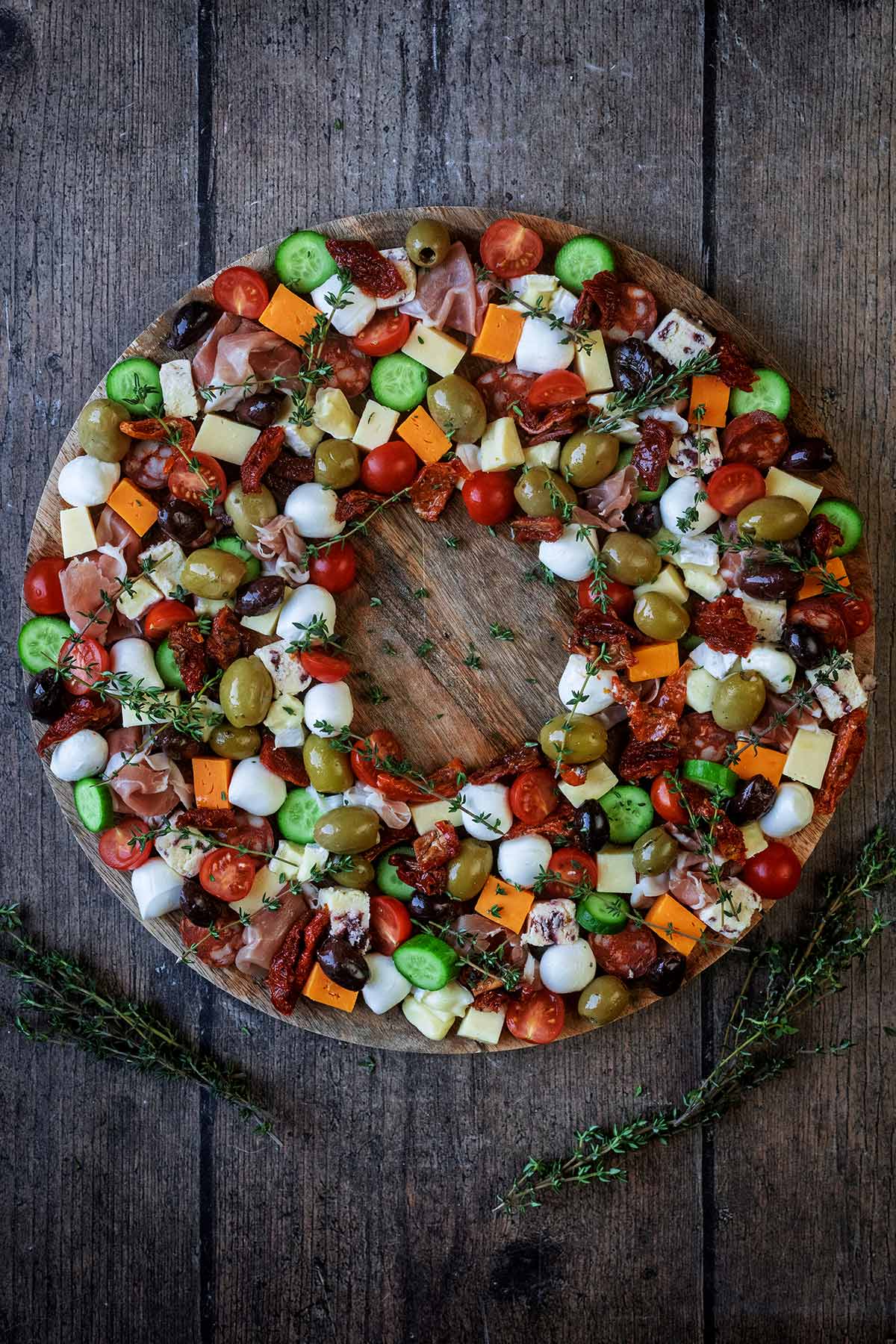 Antipasto arranged on a round board in the shape of a Christmas wreath.