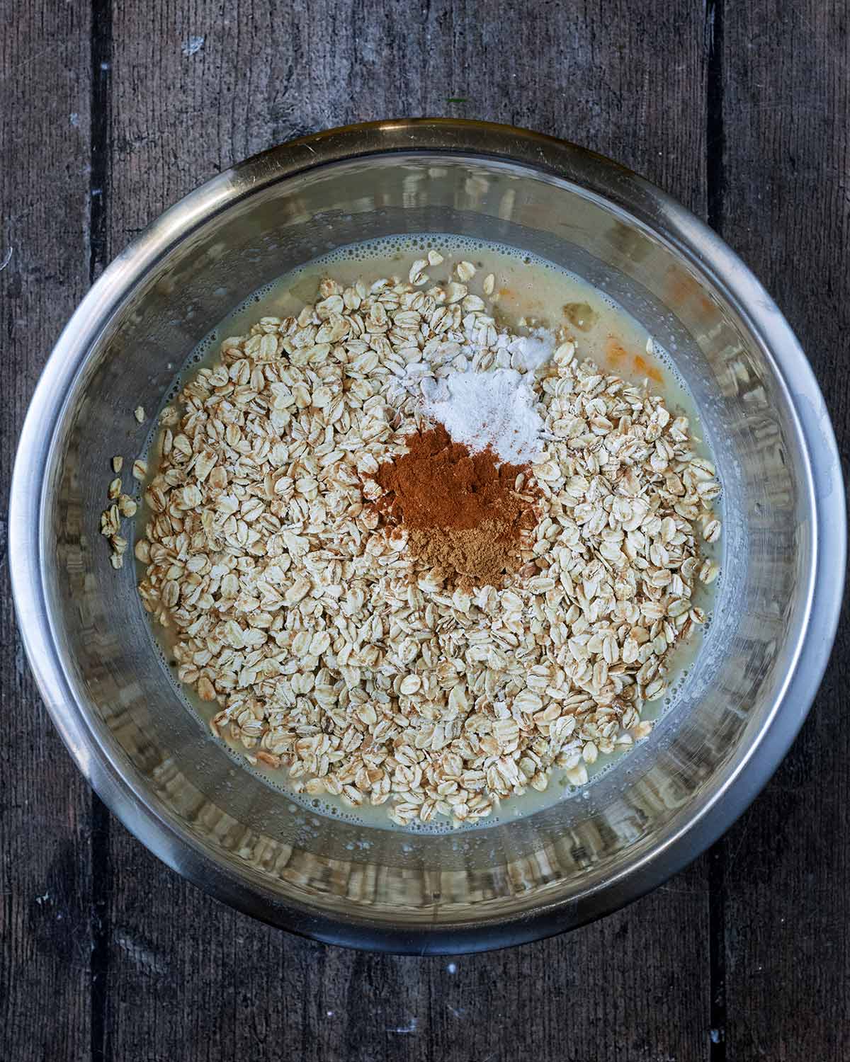 Oats, cinnamon, ginger and baking powder added to the bowl.