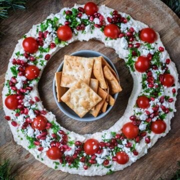 Christmas Hummus Wreath with a bowl of crackers in the middle of it.