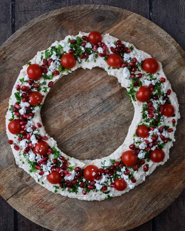 Halved cherry tomatoes, pomegranate jewels and crumbled feta added to the hummus.