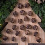 Twenty one Gingerbread Energy Balls on a wooden board.