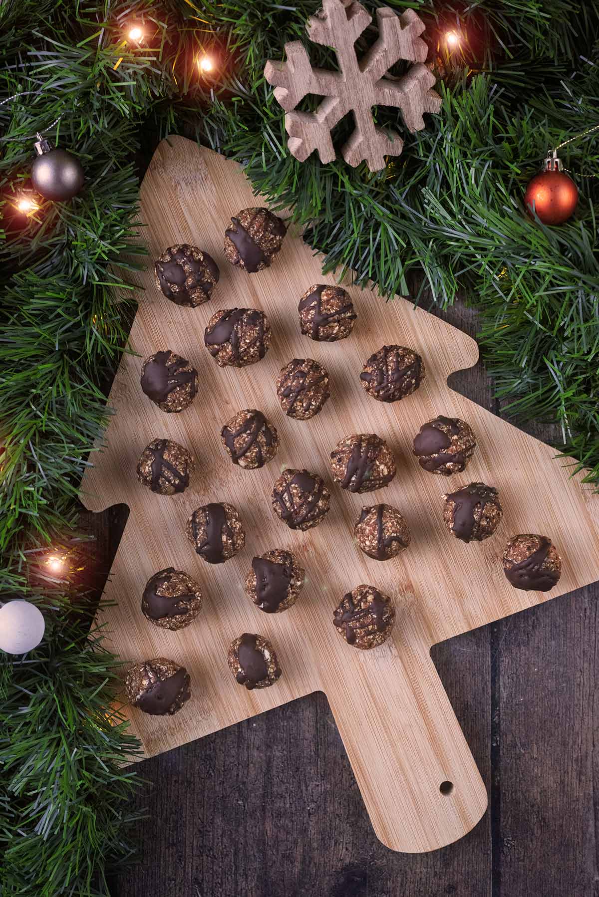 A Christmas tree shaped board covered in energy balls.