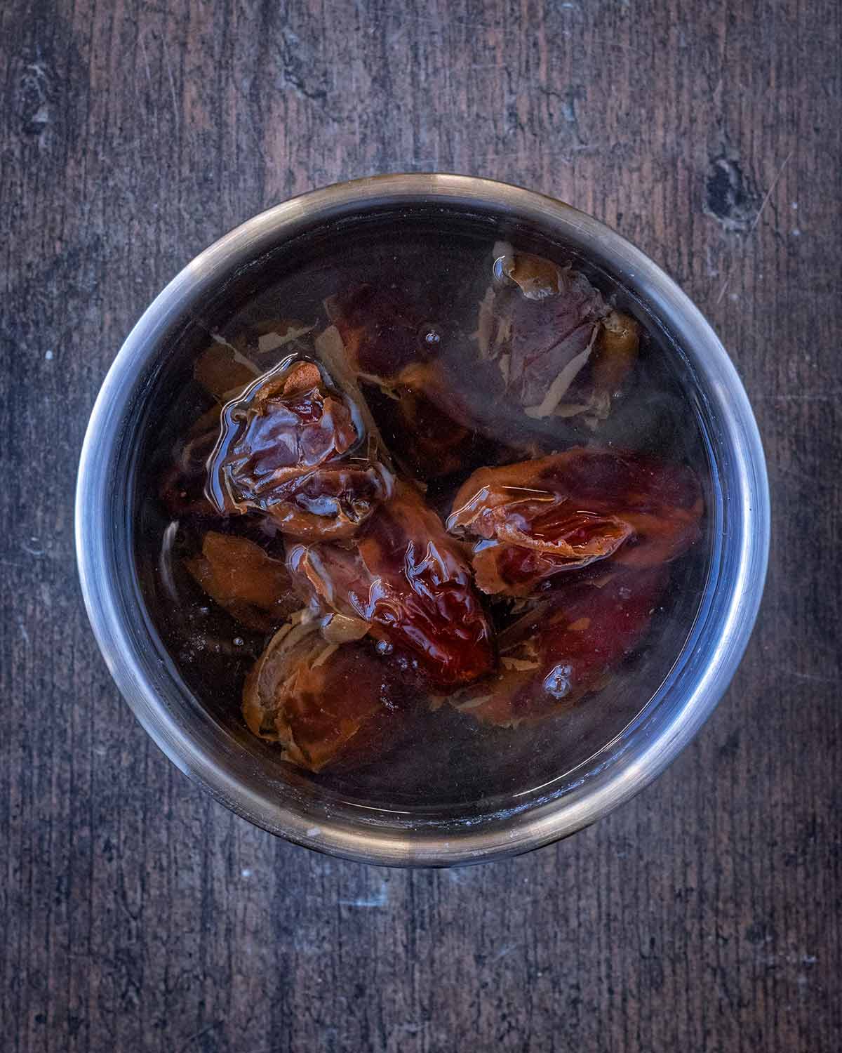 Large dates in a bowl of water.