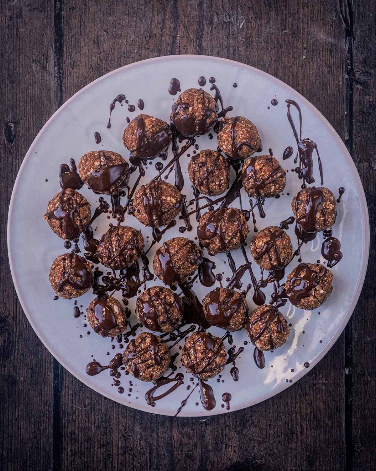 Melted chocolate drizzled over the energy balls.