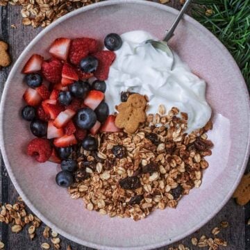 A bowl of gingerbread granola, yogurt and berries.