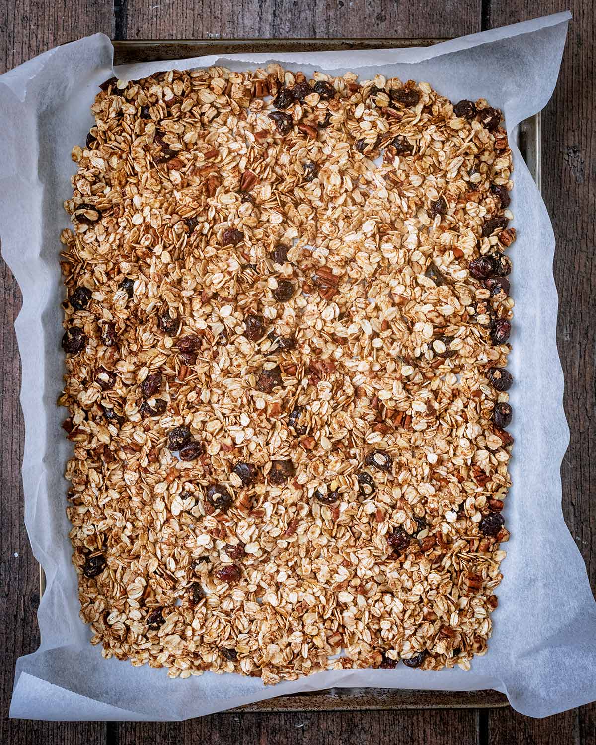Uncooked granola spread over a baking tray.