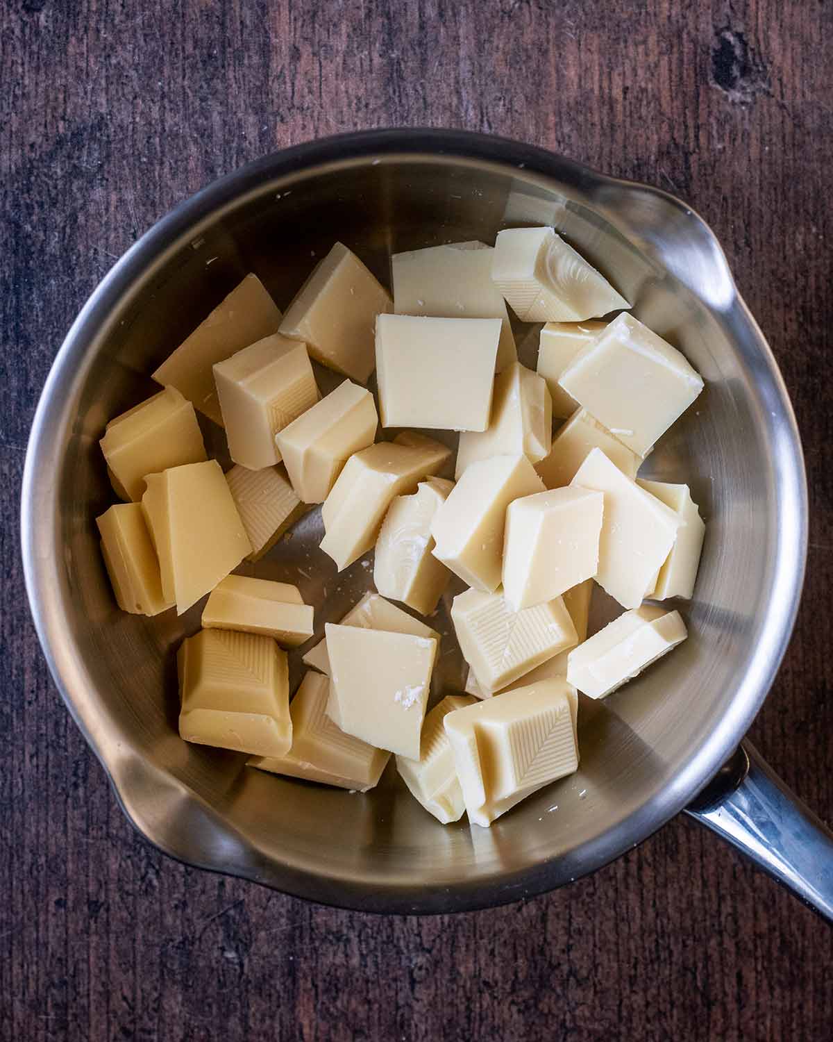 Chunks of white chocolate in a saucepan.