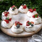 A ring of mini pavlovas dusted with icing sugar.
