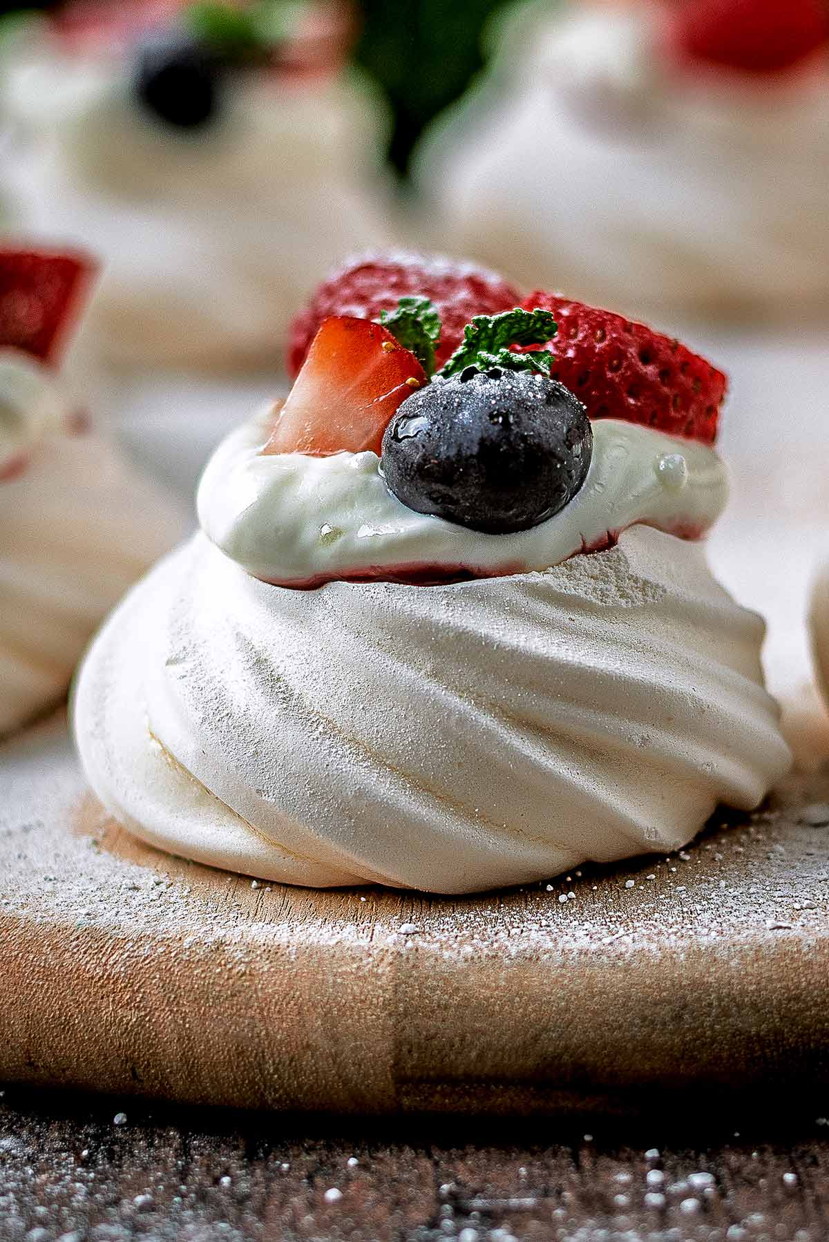A meringue nest topped with jam, yogurt and berries.