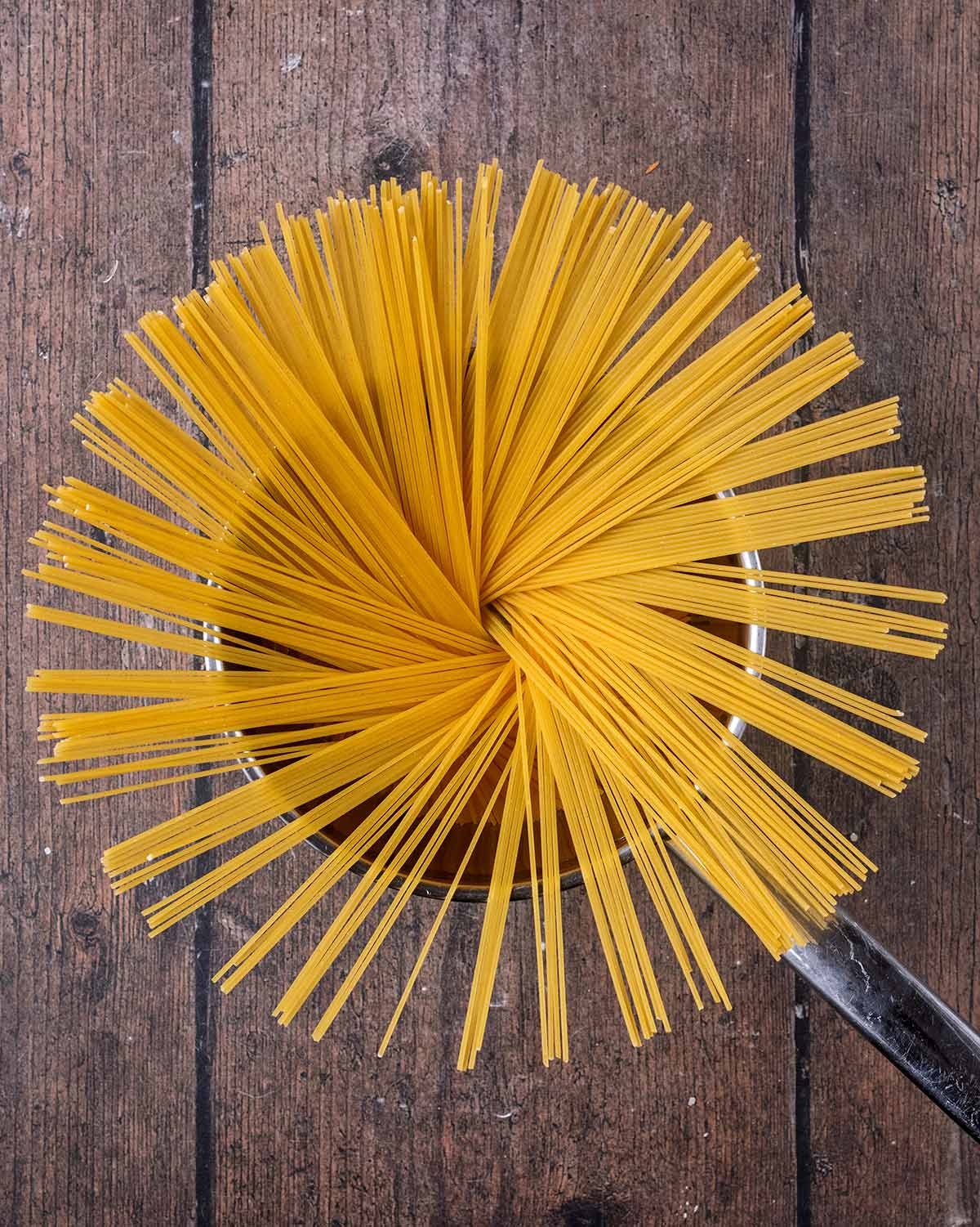 A saucepan with spaghetti in it.