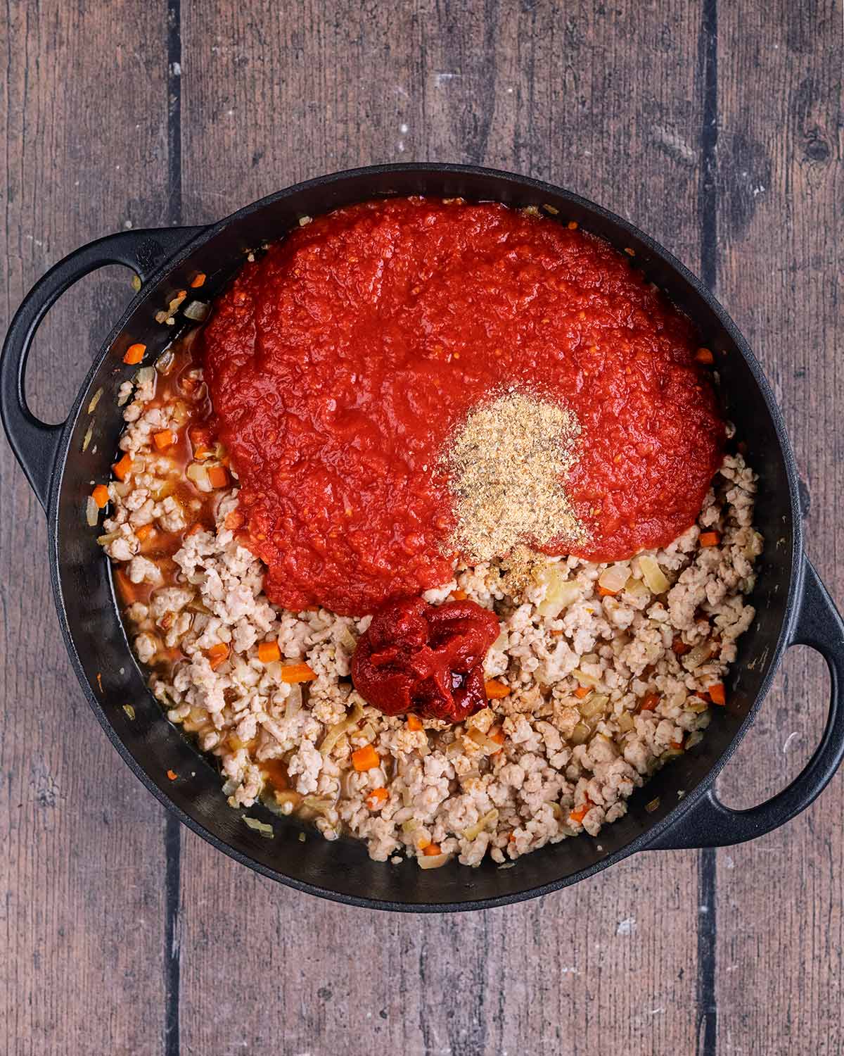 Chopped tomatoes, tomato puree and seasoning added to the pan.