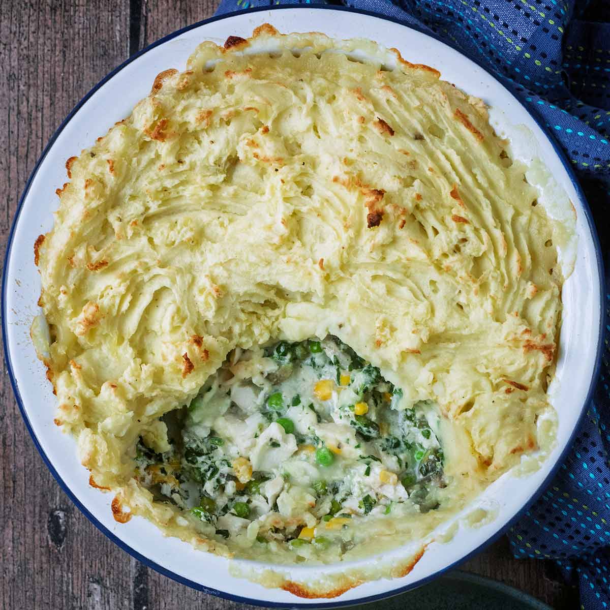 Cheat's fish pie in a round baking dish.